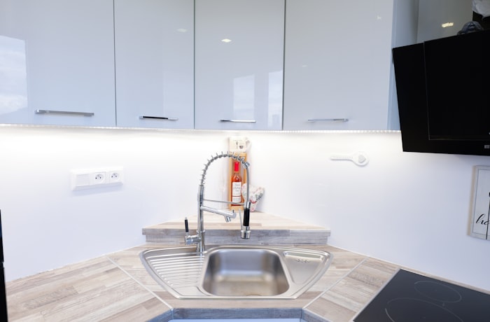 Modern kitchen sink with white cabinets and countertop