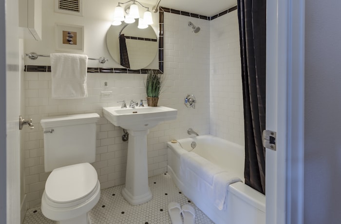 Clean modern bathroom with white toilet and pedestal sink